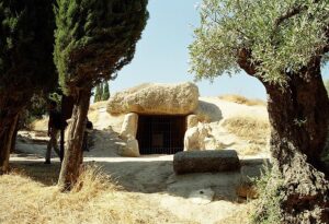 Entrada do Dolmen de Menga, uma antiga tumba megalítica na Espanha, mostrando a imponente estrutura de pedras gigantes alinhadas com precisão.